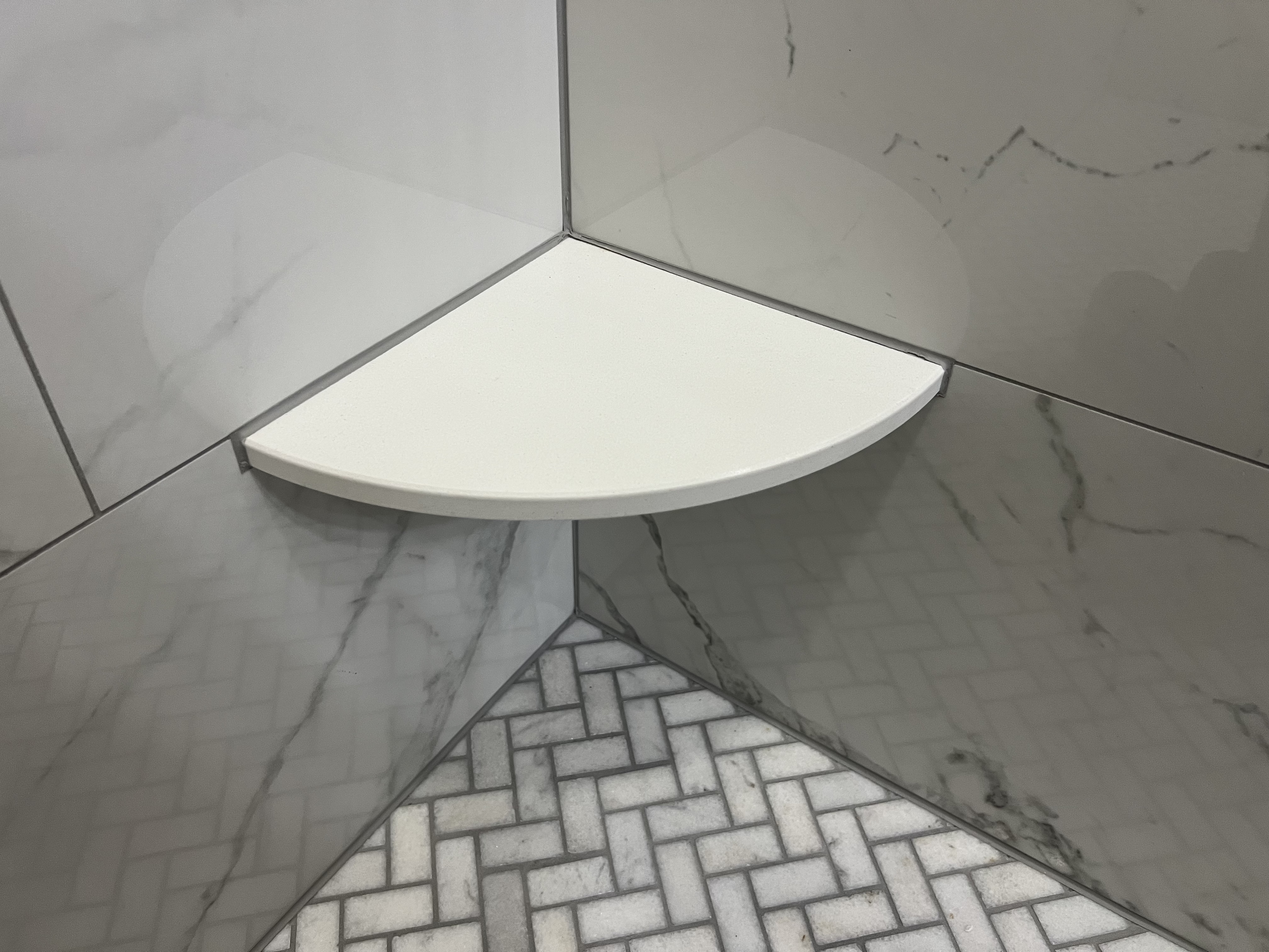 Quartz corner shower shelf with Schluter edge trim