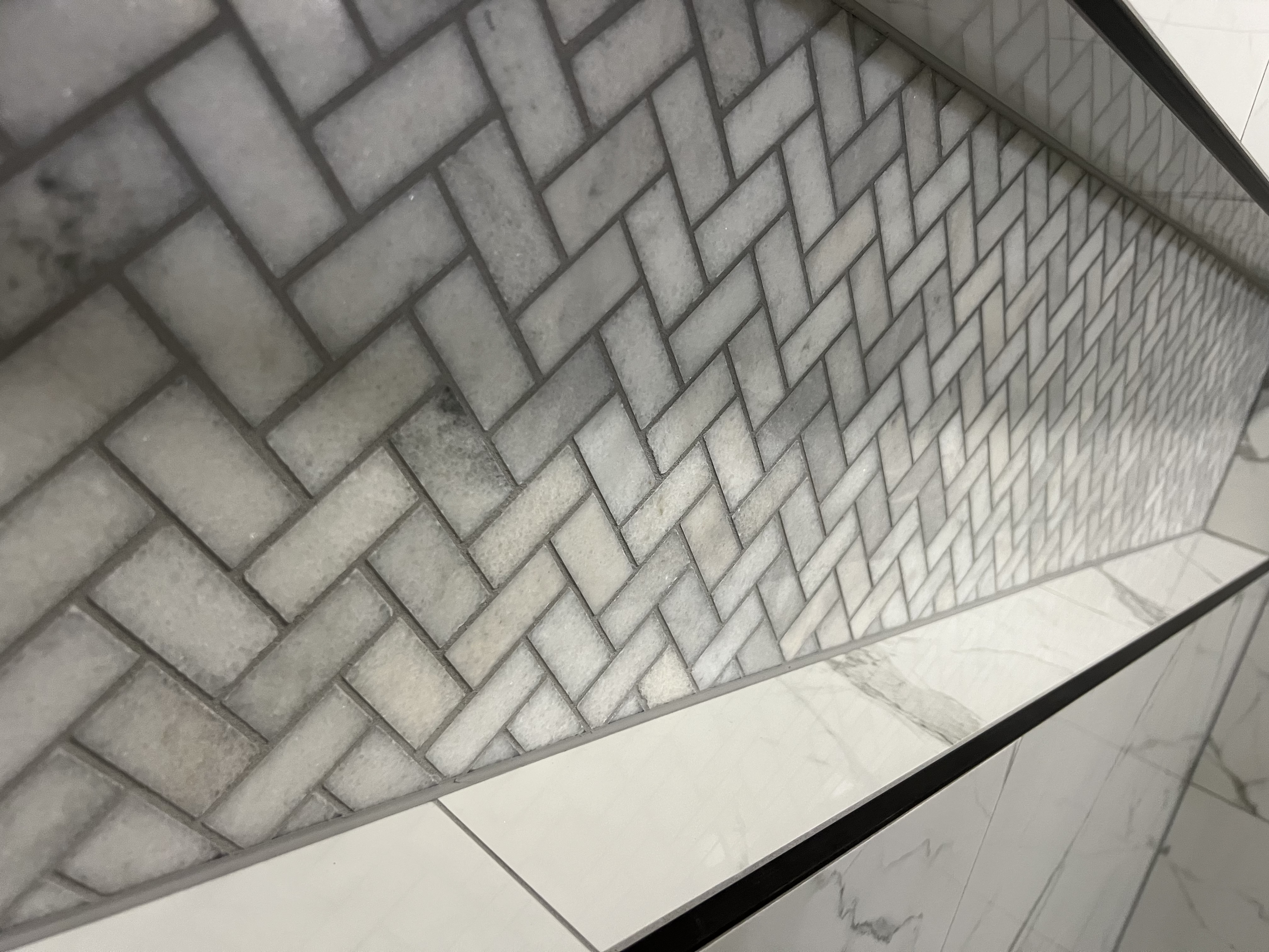 Herringbone marble mosaic shower niche with Schluter trim