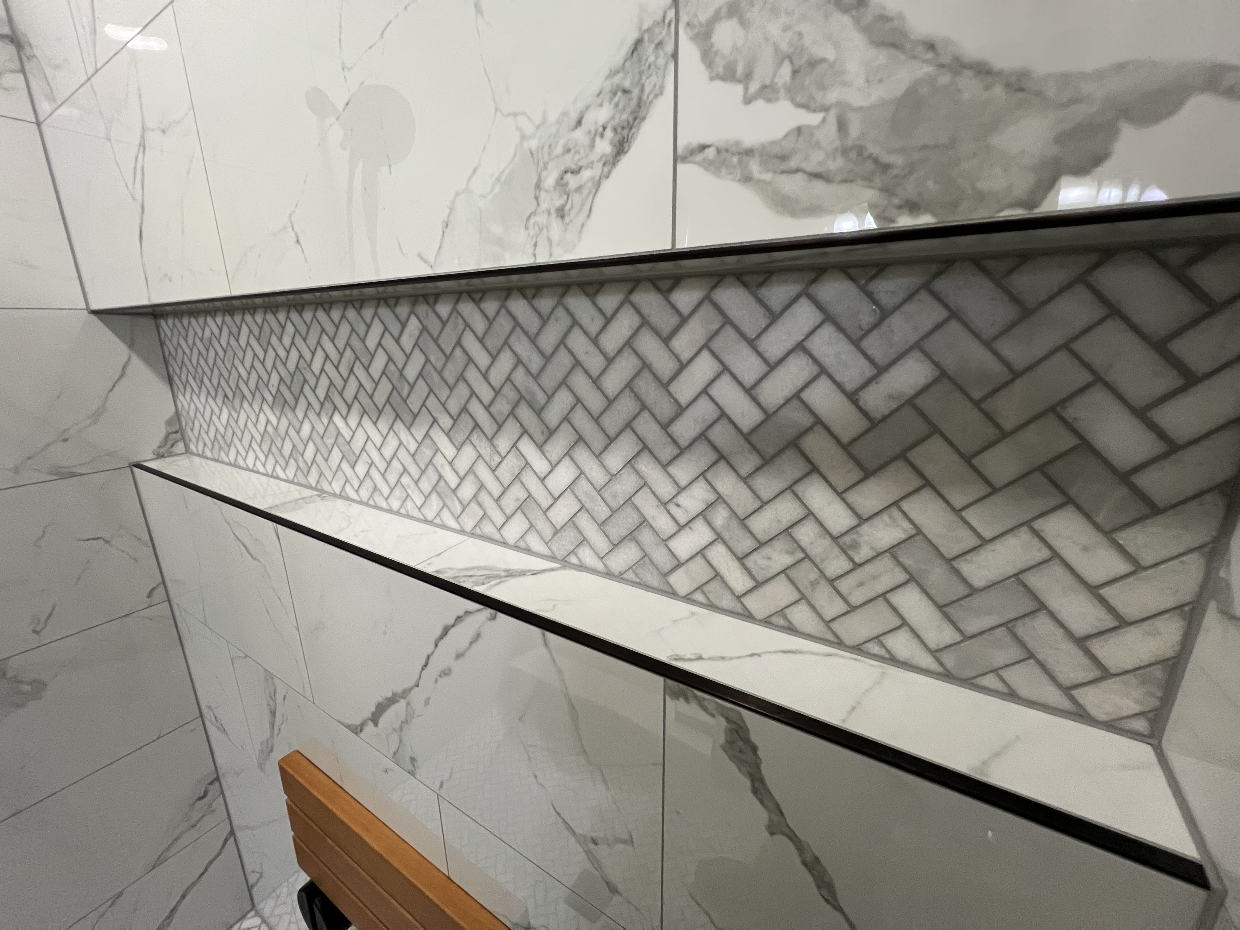 Close up herringbone marble mosaic shower niche